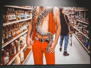 uomo con serpente nel supermercato fotografato da Mc Curry