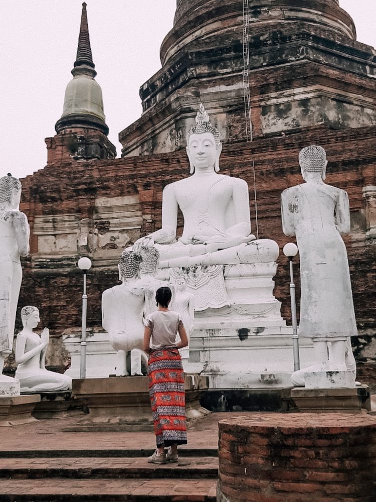 dinanzi alla statua di Buddha ad Ayutthaya
